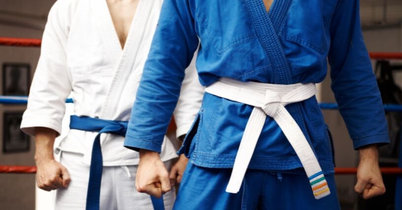 Osoby w kimonach do karate stoją w pozycji gotowości