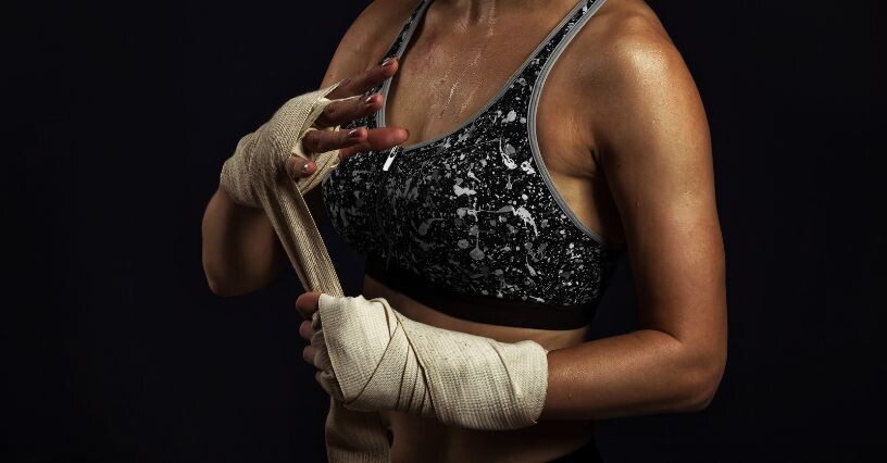 Osoba si obväzuje boxerské bandáže na rukách