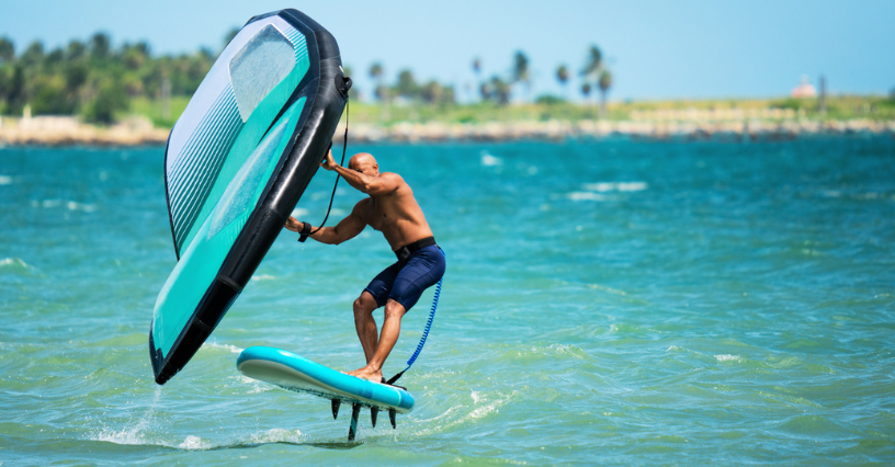 Osoba jazdí na vode na wingfoile s krídlom