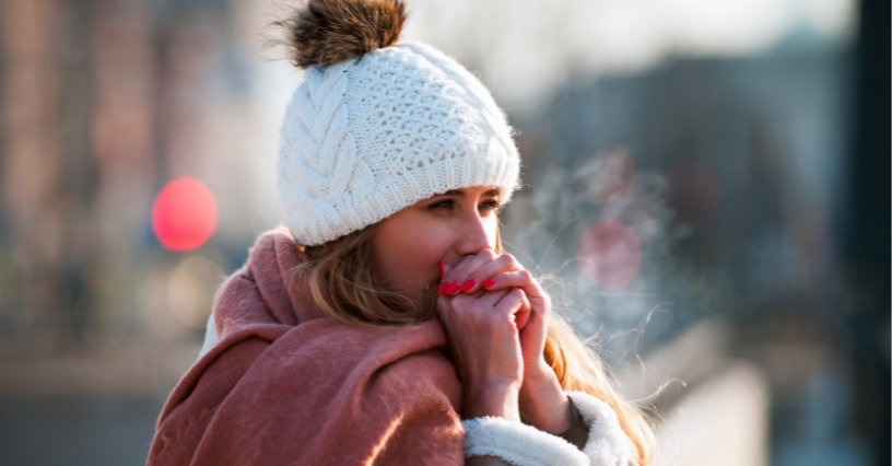 Osoba v čiapke sa zahrieva vonku