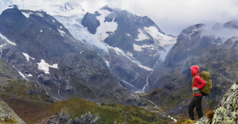 Osoba s batohom sa pozerá na horskú scenériu