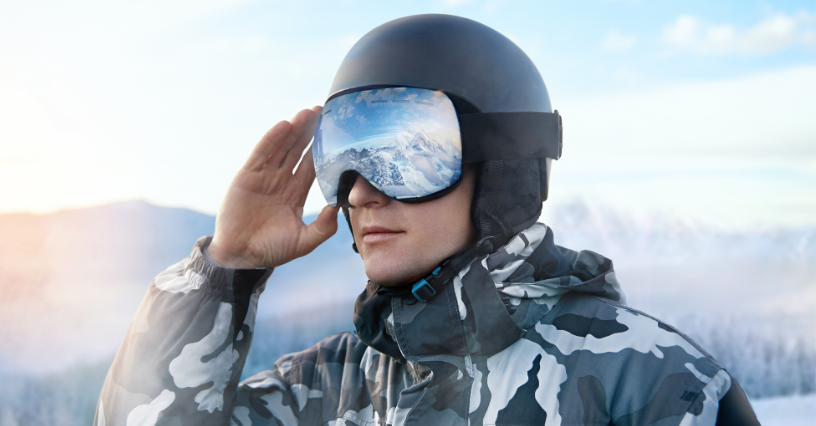 Osoba v lyžiarskej prilbe a okuliaroch na zasneženej hore