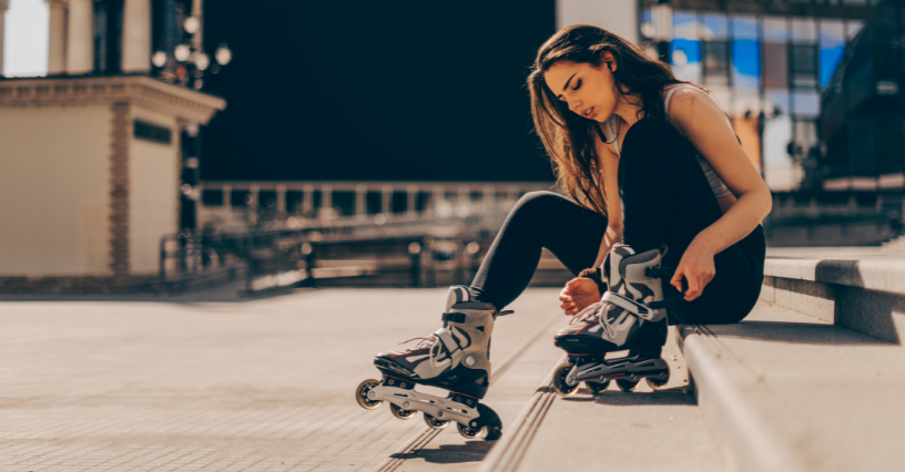 Osoba si obúva kolieskové korčule na schodoch