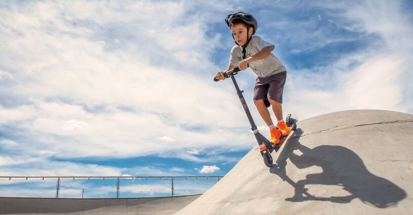 Chlapec jazdí na kolobežke v skateparku