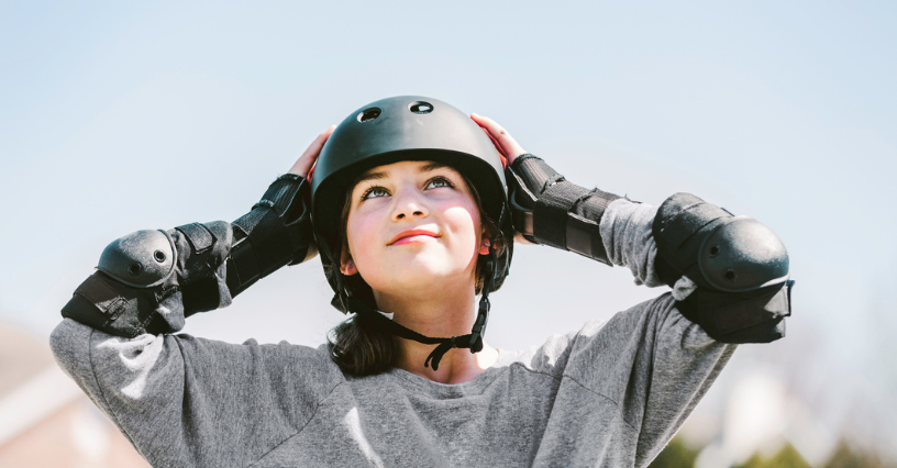 Osoba v helme sa pripravuje na jazdu na kolieskových korčuliach