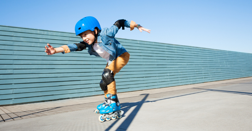 Dieťa na kolieskových korčuliach s ochrannými pomôckami