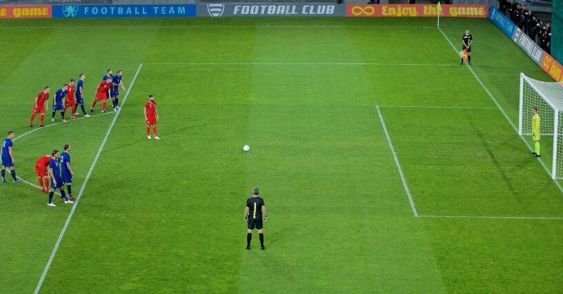 Hráč sa pripravuje na vykonanie pokutového kopu počas futbalového zápasu